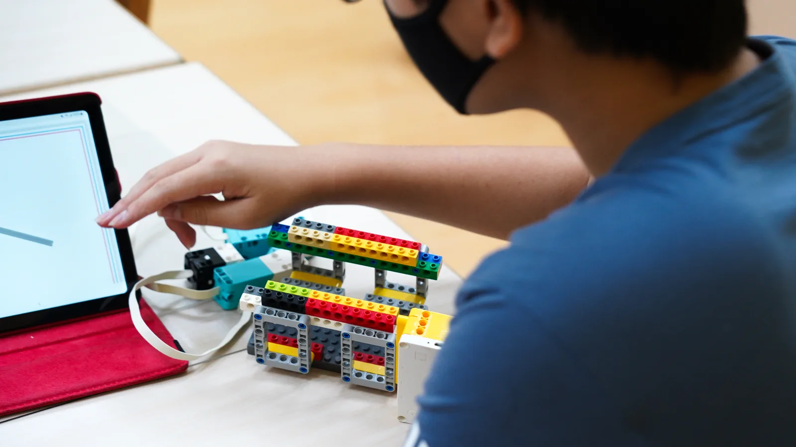 Child programming a robotics project with a tablet
