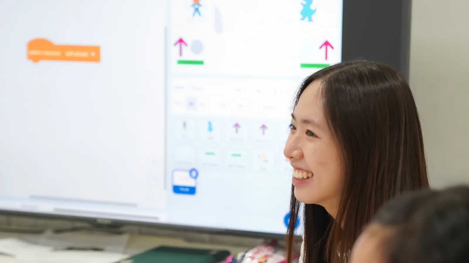 Instructor supporting children as they learn Scratch coding